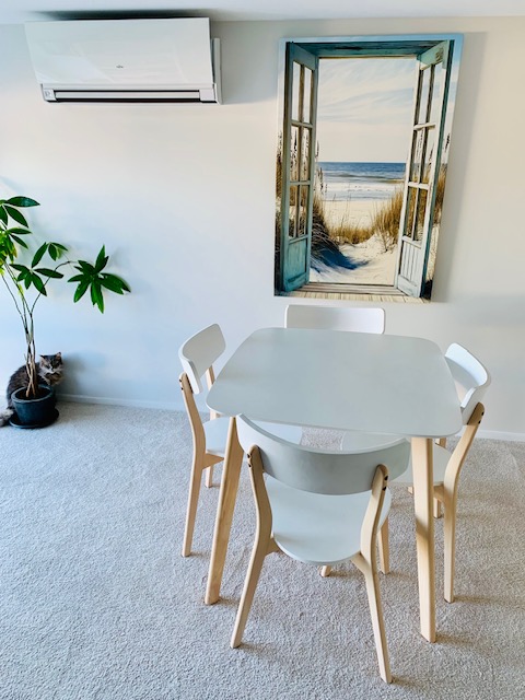 Dining area inside the studio with coastal wall art.