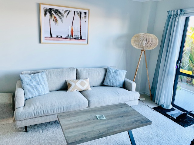 Light-filled lounge area inside CaliKiwis Studio with sofa and deck access.