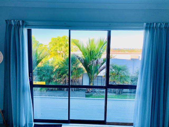 View from the studio windows across the deck, tropical planting, and sea beyond.