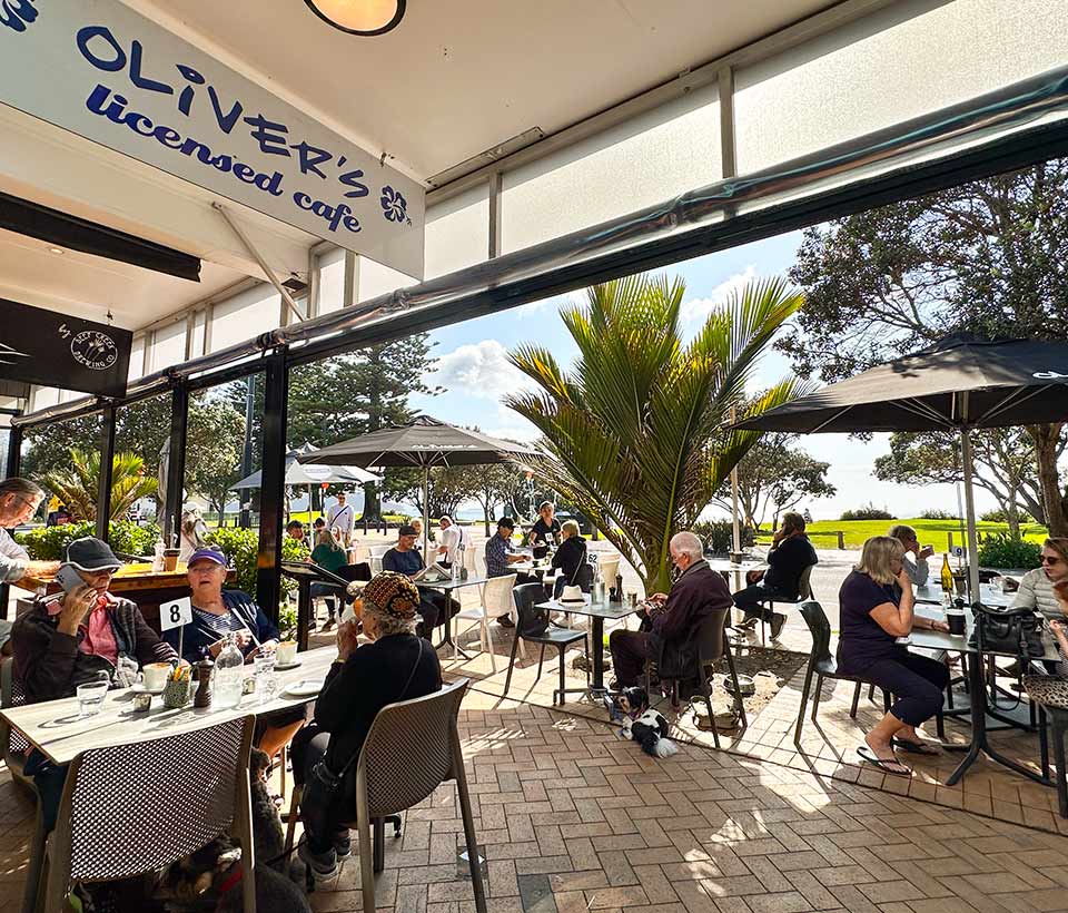 Busy Orewa cafe terrace on a sunny morning.